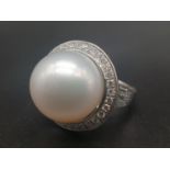 A 14 K white gold ring with a huge (18mm) perfectly spherical Okymoto pearl , with diamonds on the