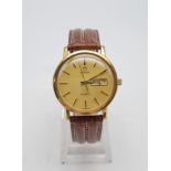 An Omega Gents Wristwatch. Gold plated and steel case -34mm. Champagne dial. Brown Leather strap.