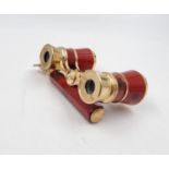 A Pair of Gilded and Red Enamel Opera Glasses. Adjustable handle, focus wheel and carry pouch. In