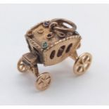 A 14 K yellow gold charm in the form of a carriage with moving wheels! Weight: 4 g.
