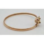 A 9K Yellow Gold Bangle with Cat-Head Clasp. Ruby eye decoration. 7.8g.