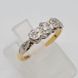 An 18K yellow Gold Three Stone Diamond Ring. Size L. 2.47g