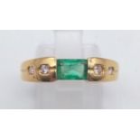 An 18 K yellow gold ring with an emerald cut emerald and diamonds on the shoulders. ring size: O,