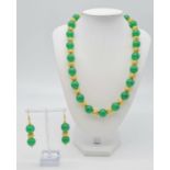 A green jade and 18 K yellow gold plated necklace and earrings set in a presentation box. Necklace