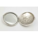 A sterling silver, mirrored, compact. Diameter: 6.6 cm, weight: 52.4 g.