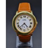 A CARTIER CIRCULAR LADIES GOLD PLATED WATCH WITH DUAL TONE FACE, ROMAN NUMERALS , SECOND HAND AND
