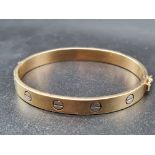 AN 18K YELLOW GOLD CARTIER STYLE CHILDRENS BANGLE. 10.3gms