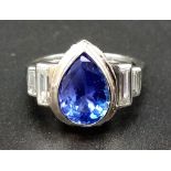 AN 18K WHITE GOLD CARTIER RING WITH A LARGE PEAR SHAPED TANZANITE CENTRE STONE WITH DIAMOND BAGUETTE