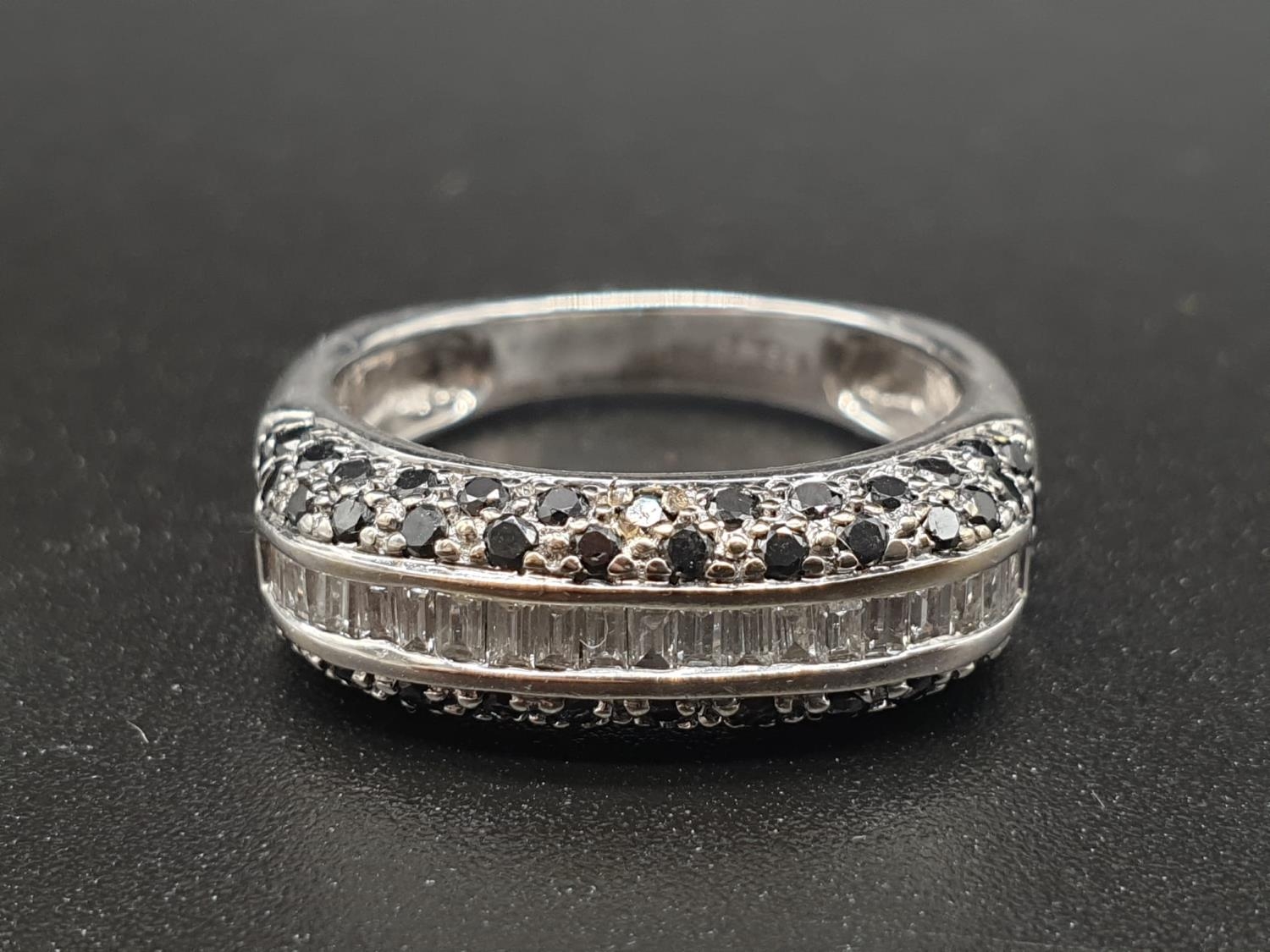 An 18K White Gold White and Black Diamond Ring. Size P. 1ct diamond, 6.3g
