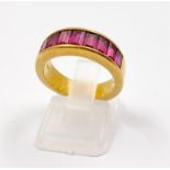 An 18K Yellow Gold Nine-Stone Ruby Band Ring. Baguette-cut vibrant purple-red natural rubies. Size