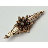 An Antique 15K Yellow Gold and Diamond Bar Brooch. Central floral diamond design. 6cm. 6g total