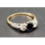 An 18K Yellow Gold and Platinum Three Stone Diamond and Sapphire Ring. 0.5ct - sapphire. 0.10ct -