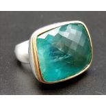 A White Metal with Gold Trim Aquamarine Ring. Large central stone surrounded by gold trim. Size R.