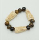 An Early Chinese Ivory and Tigers Eye Bracelet. Buddha - 4cm. 85g total weight.