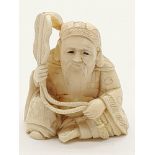 An early Japanese, carved ivory, figurine of a seated sage with a fan. Dimensions: 5.5 x 5 x 3.5 cm,