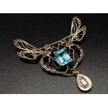 A delicate brooch of two dragon flies drinking from a central emerald cut aquamarine. Combination of