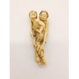A 19th Century carved ivory Netsuke figure of a mother and child catching an octopus. Height: 8