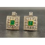 An 18 K white gold pair of earrings with central emerald surrounded by diamonds. Total weight: 7 g.
