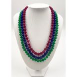 A Sensational 600ct Natural Emerald, Ruby and Sapphire Three-Row Smooth-Bead Necklace. Silver-