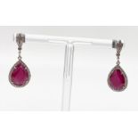 An 18 K white gold pair of earrings with large tear drop shaped rubies. Drop: 3 cm, weight: 5.2 g.