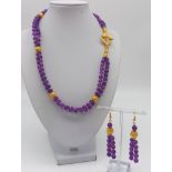 A double row of round amethysts necklace and earrings set with 18 K yellow gold plated highlights.