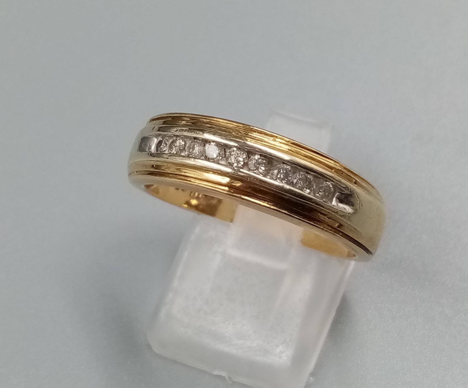 A 9 K yellow gold ring with band of diamonds. Ring size: T, weight: 5.3 g.