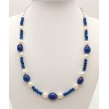 A Blue Sapphire and Freshwater Pearl Necklace. Large sapphire central bead with smaller faceted