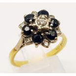 An 18K Yellow Gold Diamond and Sapphire Flower-Shaped Cluster Ring. Central diamond surrounded by