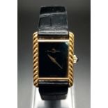 A Baume and Mercier 18K Gold Ladies Watch. Black leather strap with gold buckle. Gold case - 22 x