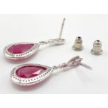 An 18 K white gold pair of earrings with large tear drop shaped rubies. Drop: 3 cm, weight: 5.2 g.