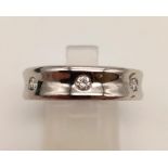 An 18K White Gold Diamond Set Band Ring. Size Q. 0.15ct. 9.1g.