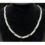 An 18K White Gold Diamond Bar-Link Necklace. 11ct of round-cut diamonds spread over 16 bar links. 96
