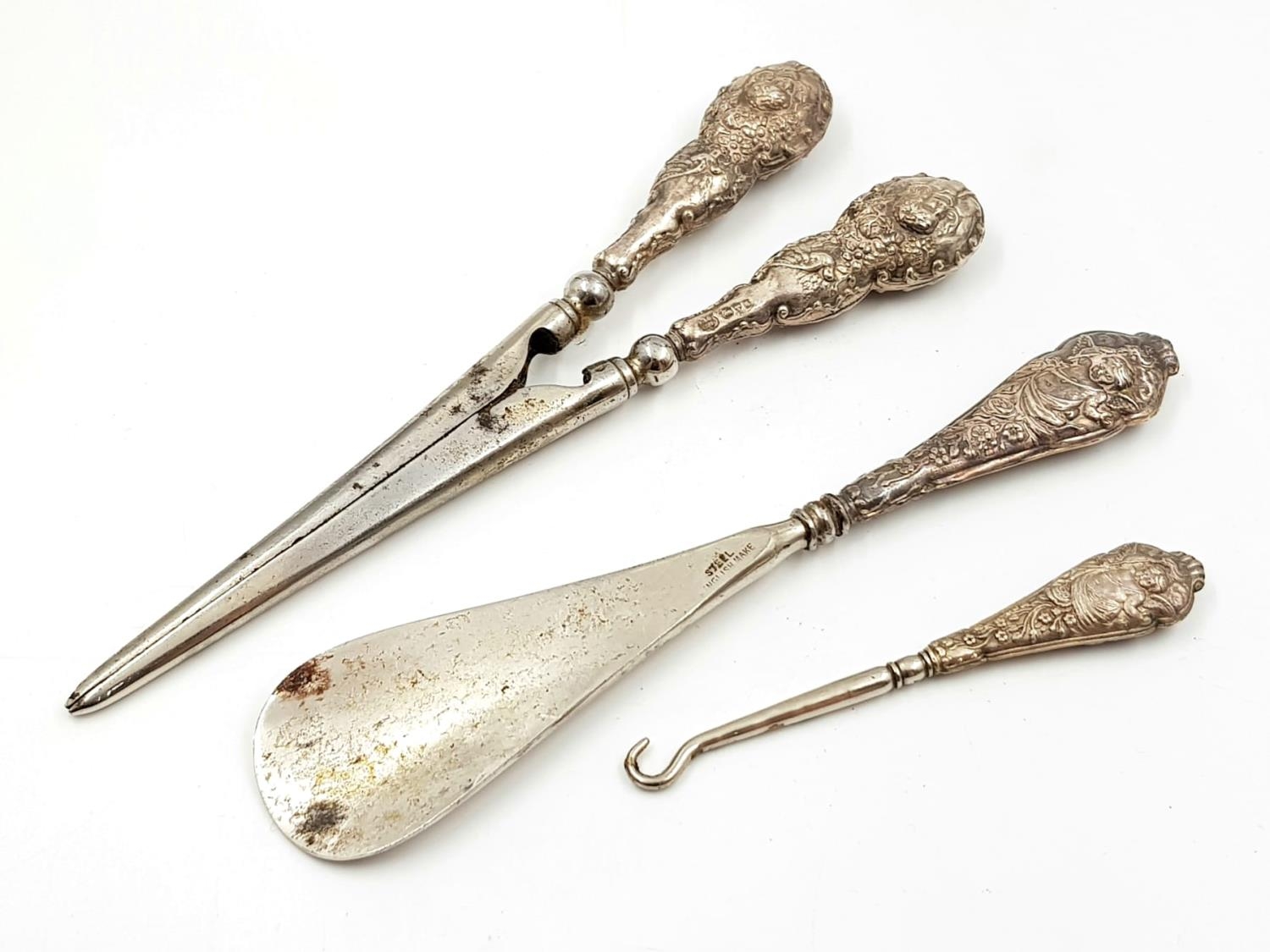 A Three Piece Victorian Outerwear Set. Glove removers - 17cm. A shoe horn - 16cm and a boot button