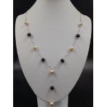 An 18K White Gold Natural South Sea Pearl and Faceted Black Diamond Necklace. Disappearing