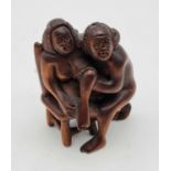 An Antique Japanese Hand-Carved Boxwood Netsuke Figurine - of a nude couple up to mischief on a