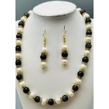 A very feminine, genuine pearl and cat?s eyes necklace and earring set, with cubic zirconia. In a