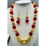 A glamorous, Chinese, red jade, necklace and earrings set with 18 K yellow gold plated dragon clasp.