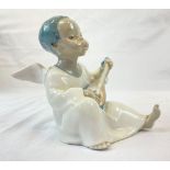 A Lladro figure of a sitting, black boy angel. Hand made in Spain. Height: 11 cm.