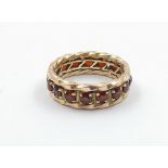 A vintage, 9 K yellow gold, full eternity ring with garnets. Ring size: M, weight: 5.27 g. In a