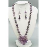 An amethyst and Tibetan silver necklace and earrings set, with a large, hand carved rose pendant.