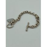 SILVER link bracelet having T bar fastening with heart pendant detail.