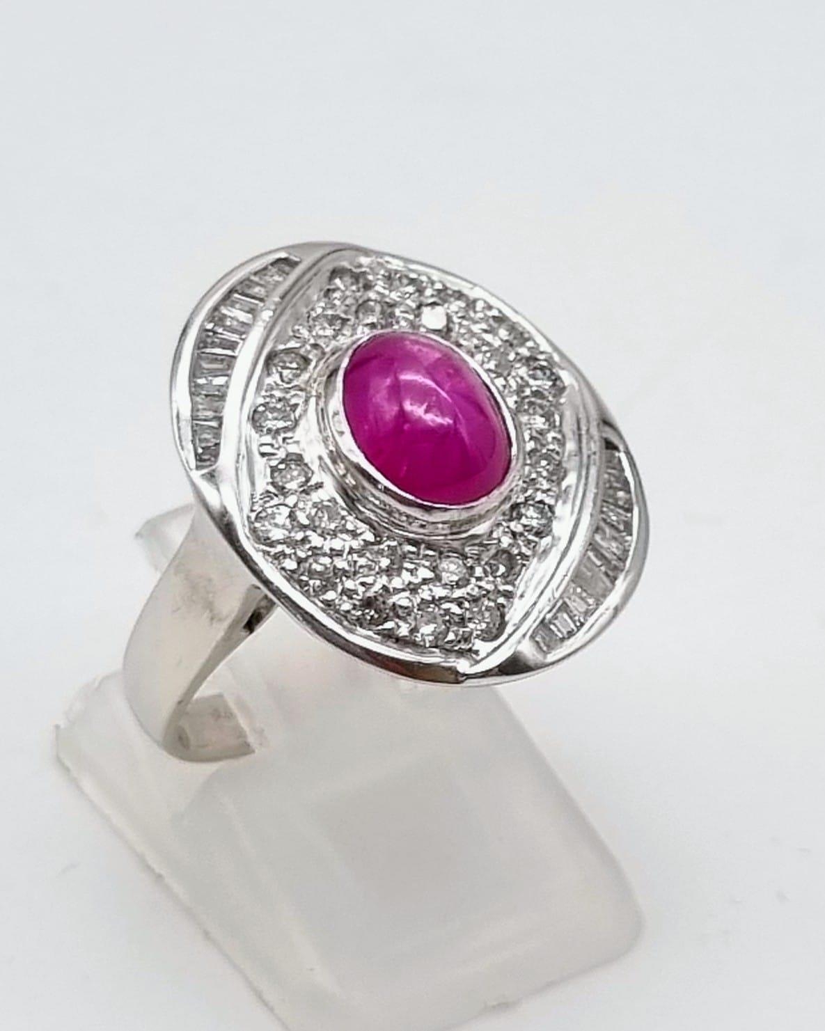An 18K White Gold Burma Star Ruby and Diamond Ring. Central Burma Star ruby surrounded by a