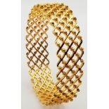 A 22K Yellow Gold Ornate Bangle. Geometric diamond pierced design with small ornate floral balls