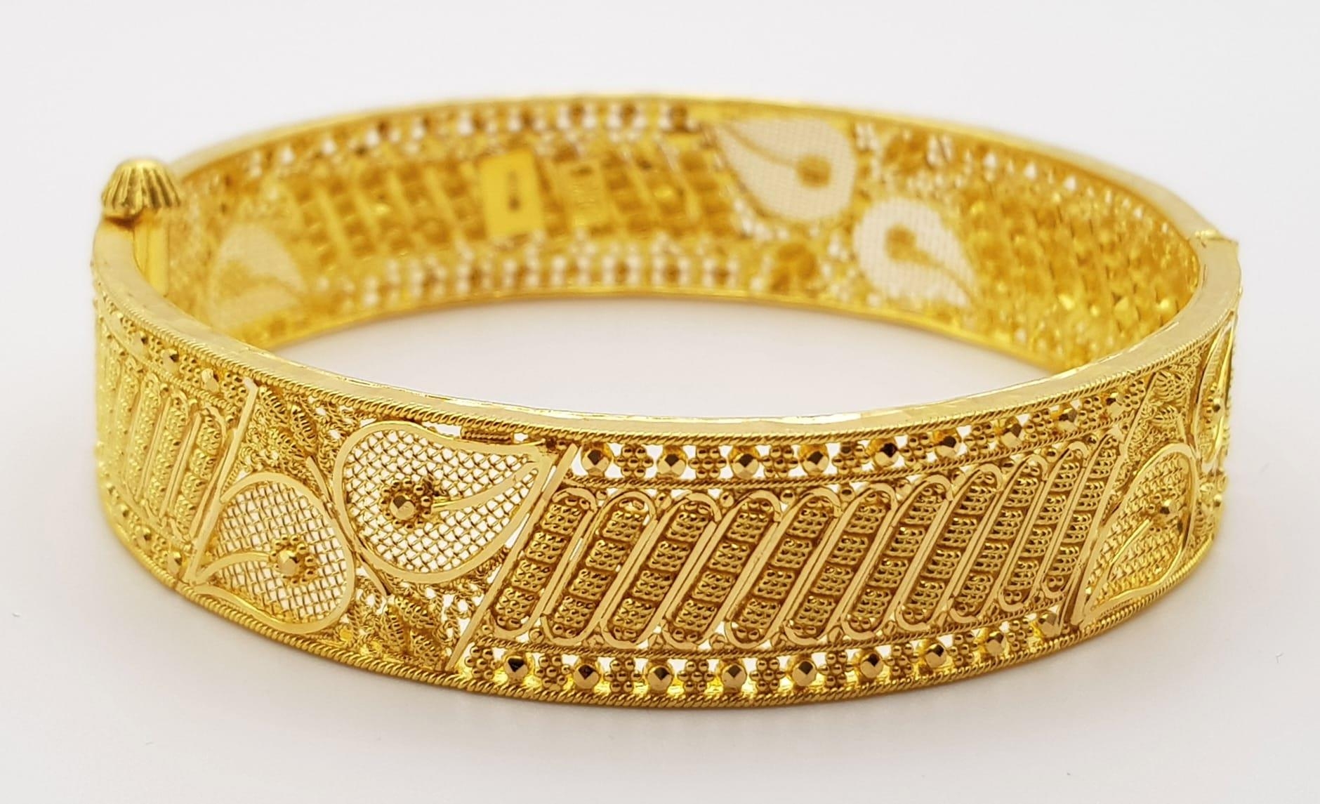 A 22K Yellow Gold Bangle. Incredible filigree and piercing decoration. Screw clasp for easy
