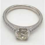 An 18K White Gold Diamond Ring. Brilliant round cut central diamond - 1.07ct. H - SI1. A further