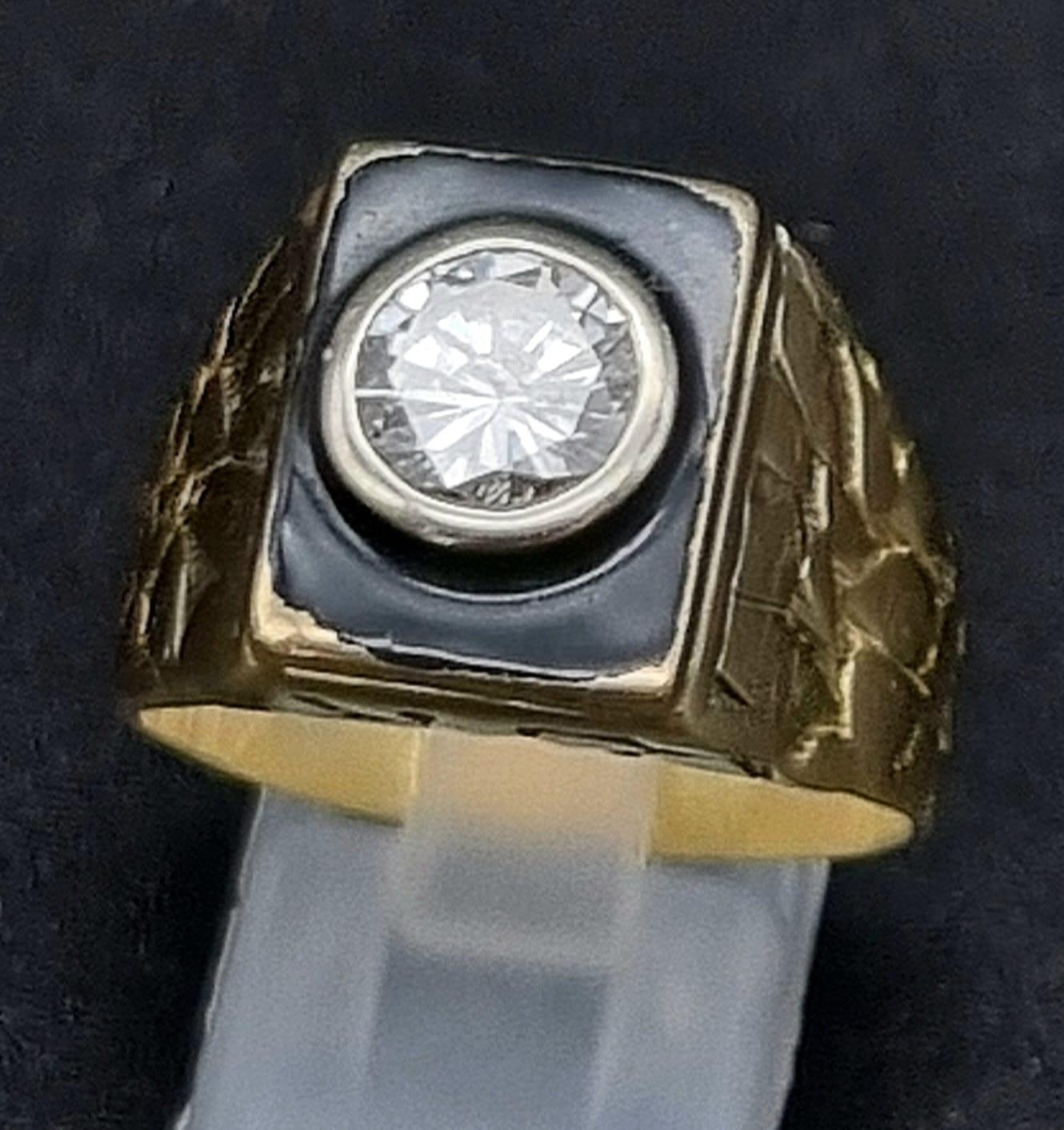 A Striking 18K Yellow Gold Black Enamel and Diamond Ring. Round brilliant cut central diamond 1.