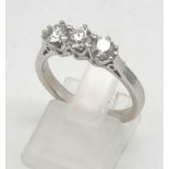 An 18K White Gold Three-Stone Diamond Ring. Brilliant round cut diamonds- 1.5ct total. Size O. 4.2g.