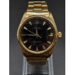 An 18K Gold Rolex Oyster Gents Watch. Gold strap and case - 35mm. Black dial. Automatic movement.