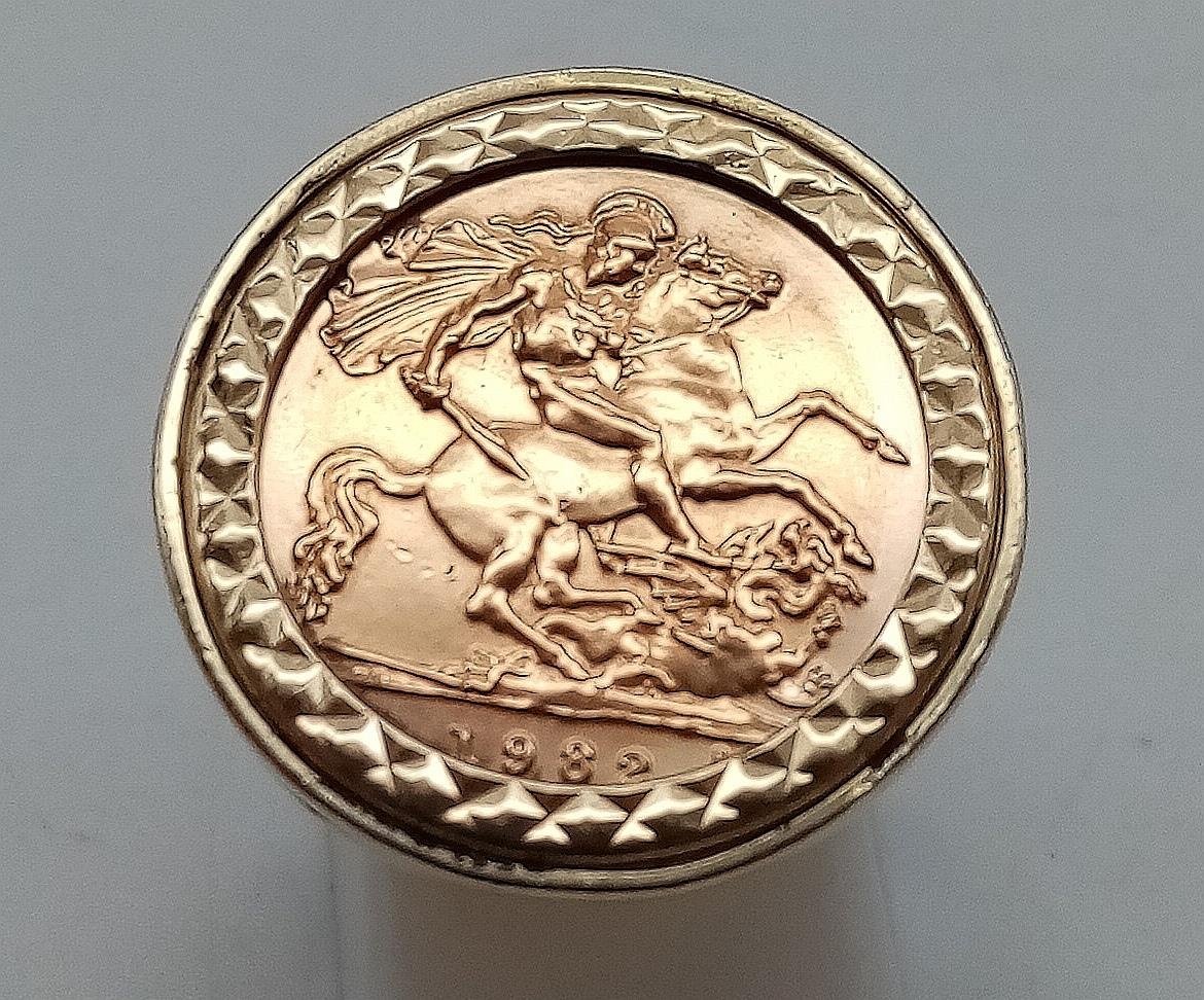 A 22K GOLD HALF SOVEREIGN SET IN 9K RING. 7.18gms