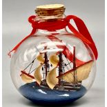 A MINATURE SHIP IN A BOTTLE. 7cms in height.